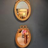 Pair of Oval Ribbon Pediment Gilt Mirrors